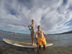 Couple Paddleboarding from our beach at our Lake Tahoe Resort